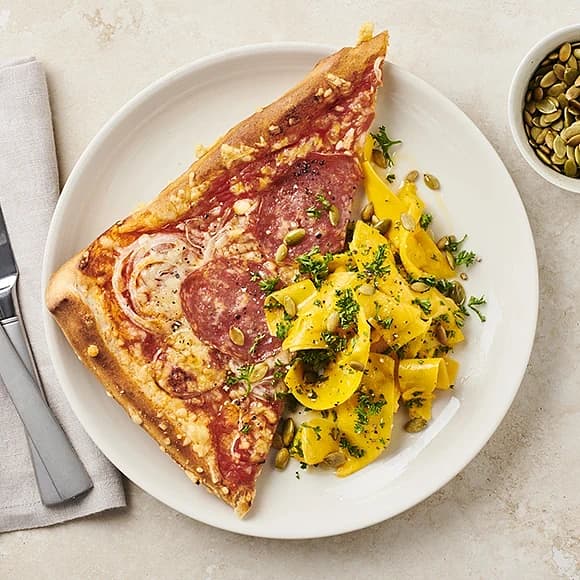Pizza med salami, silverlök och pumpasallad